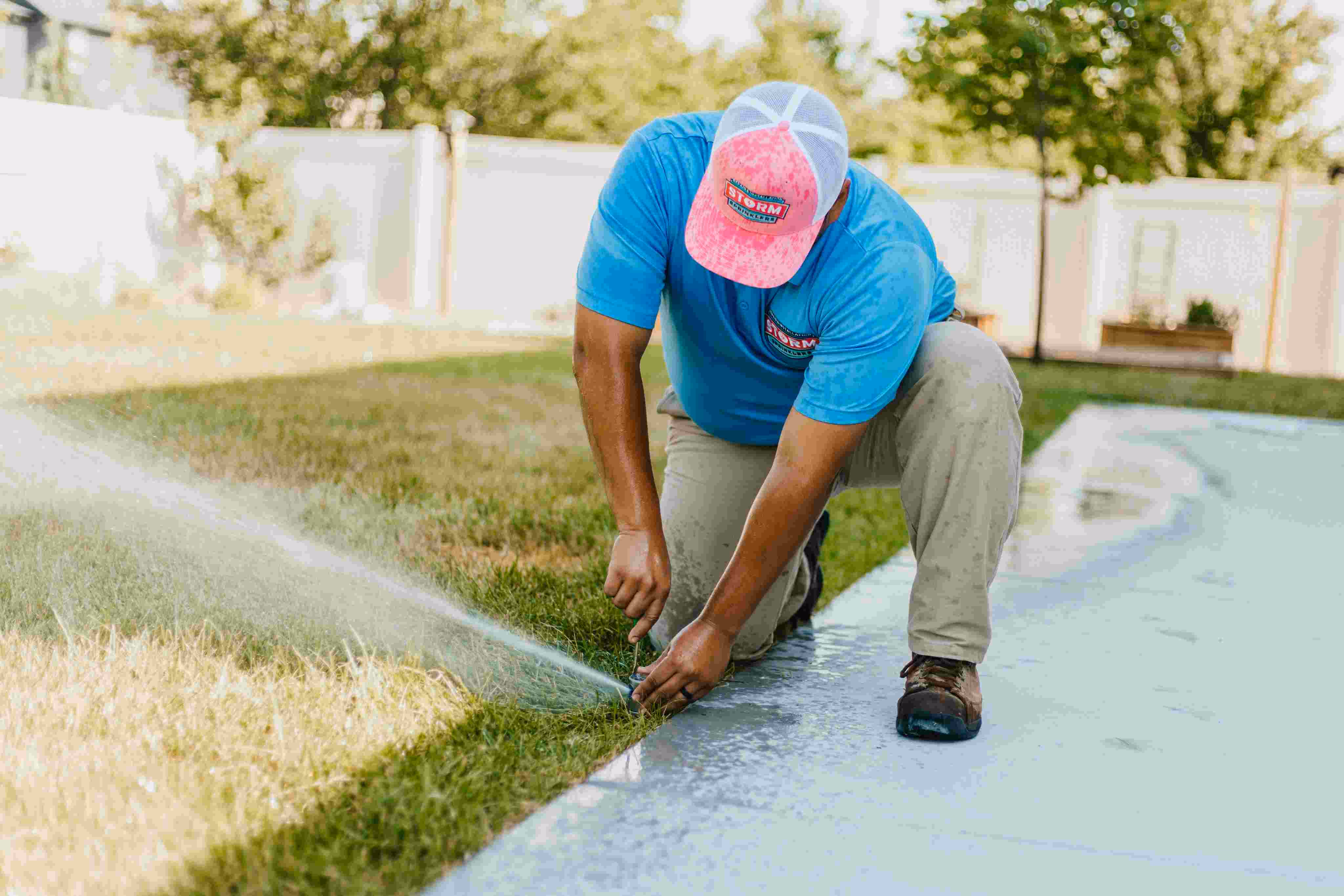 Storm Sprinklers irrigation technician adjusting rotor sprinkler head during spring tune-up in Utah County