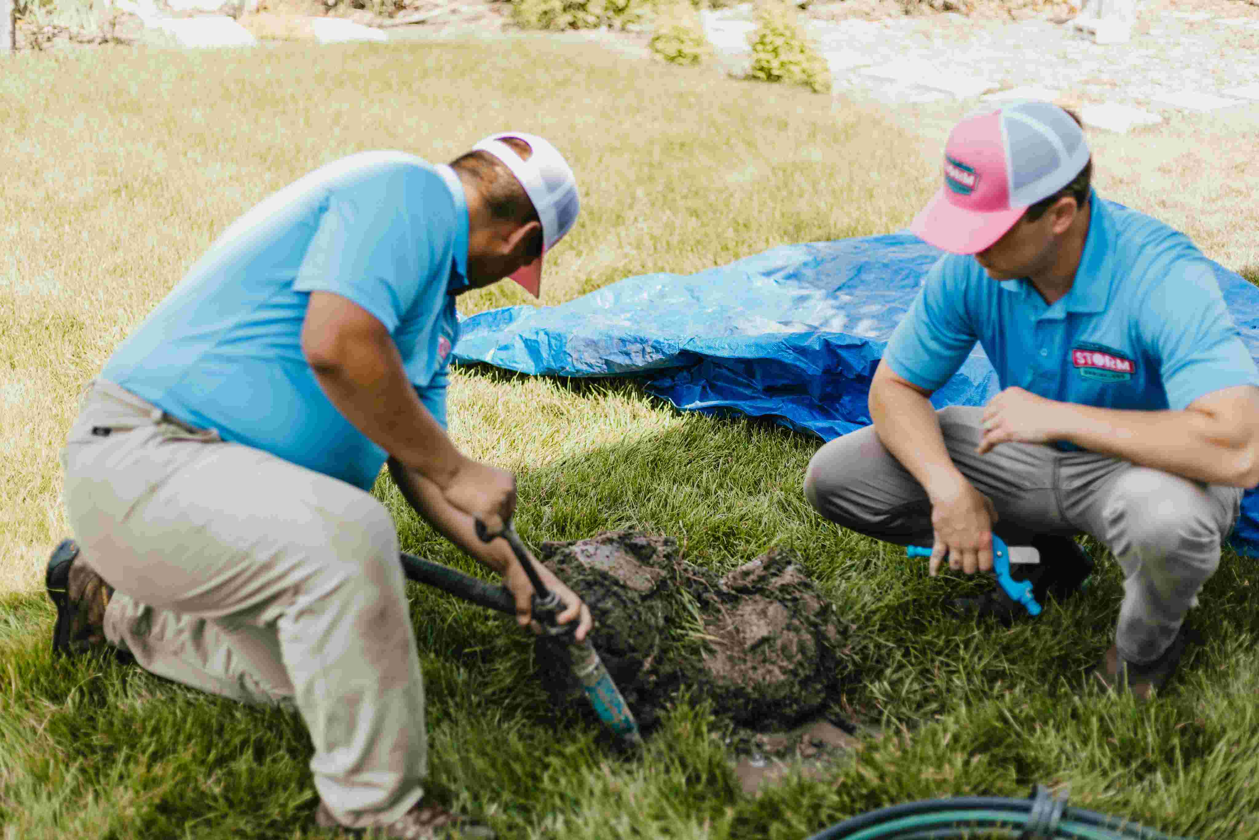 Storm Sprinklers technician repairing a sprinkler system leak in the grass