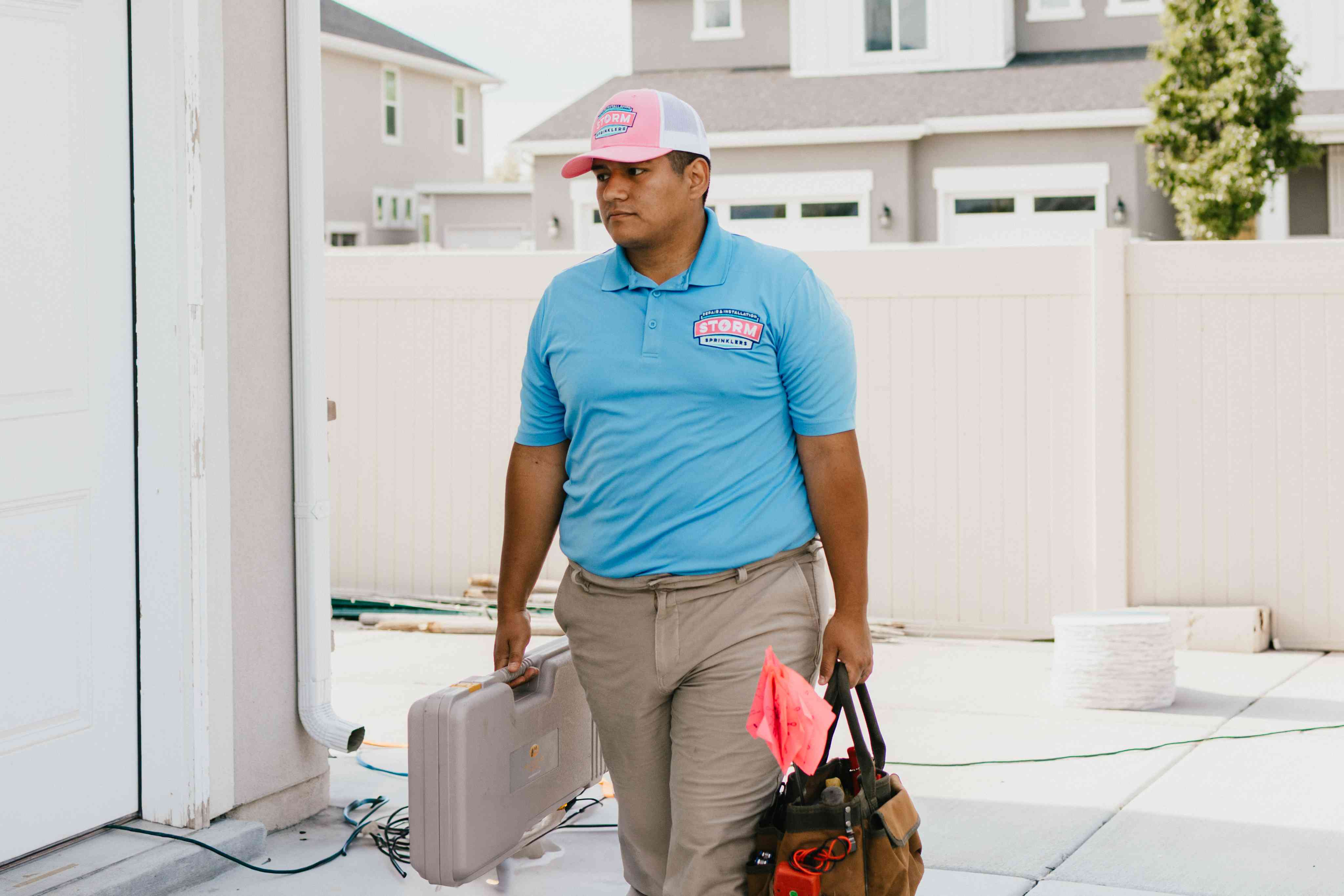 Storm Sprinklers technician carrying toolbag for commercial irrigation service