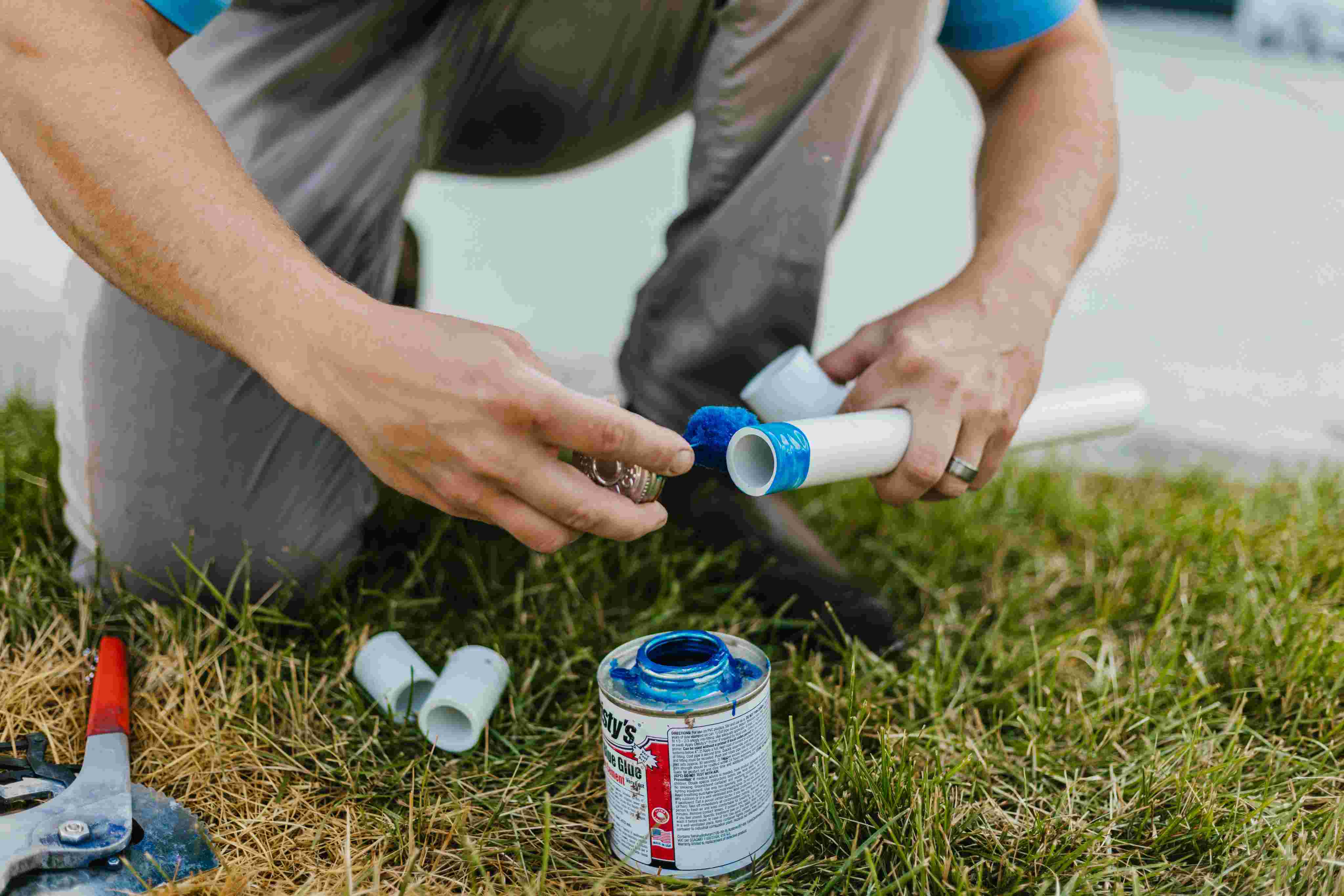 Storm Sprinklers technician gluing PVC pipe during new sprinkler system installation